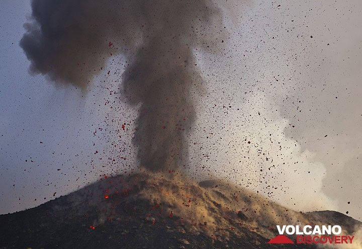 The ash plume from the eruption rises vertically while glowing bombs rain down onto the NE crater's outer flank. (Photo: Tom Pfeiffer)